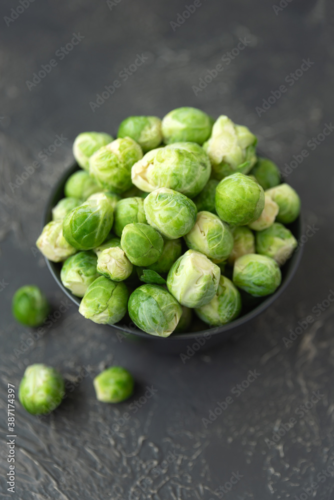 Close-up bowl with raw brussels sprouts on concrete background. Vegetarian food. Selective focus. Top view Close-up bowl with raw brussels sprouts on concrete background. Vegetarian food. Selective focus. Top view