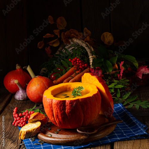 Delicious autumn pumpkin soup with baguette photo