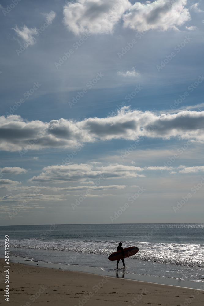 surfer walks into the Atlantic ocean on the French Cote d'Argent to catch some waves surfer walks into the Atlantic ocean on the French Cote d'Argent to catch some waves