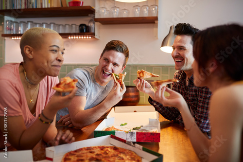 Group Of Gay Friends Meeting At Home And Eating Takeaway Pizza