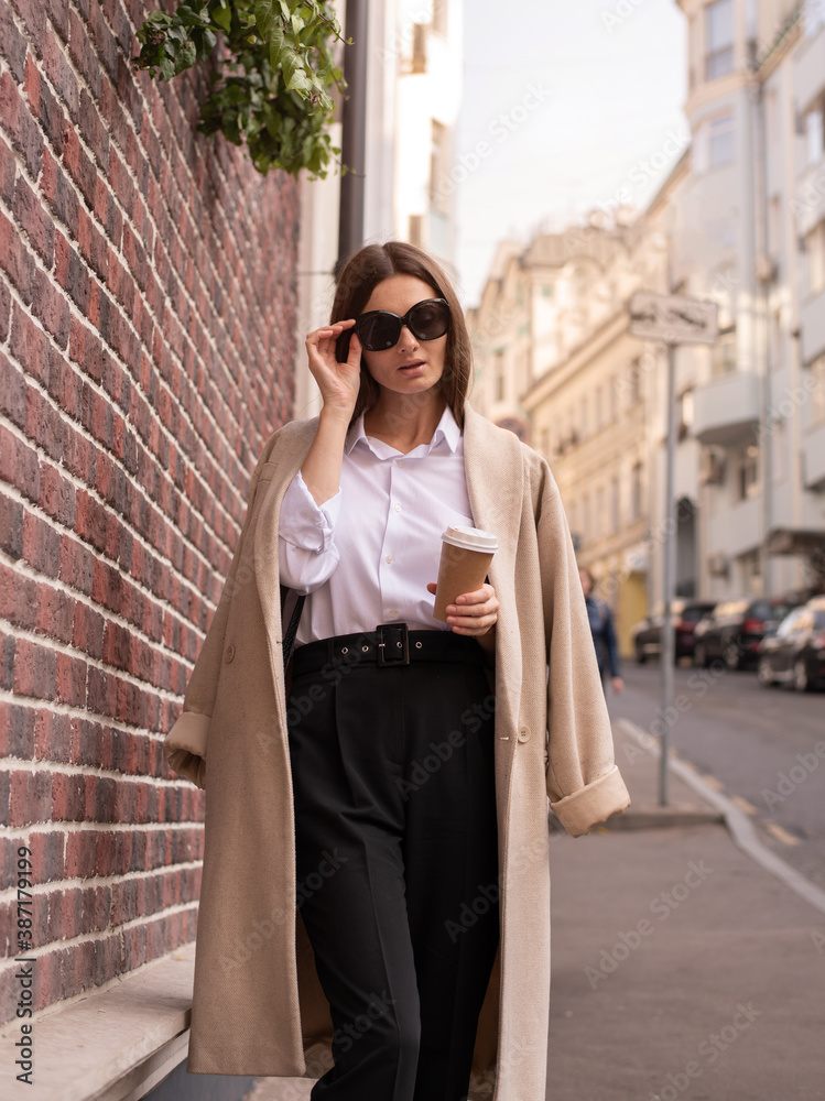 Young business woman. Walk down the street. Morning, coffee with you.