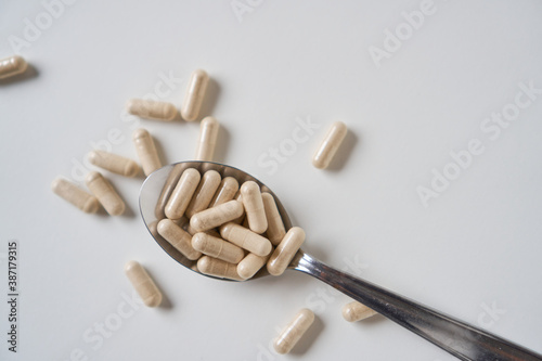 Daily Fiber Supplement. Pills in capsules on spoon. 