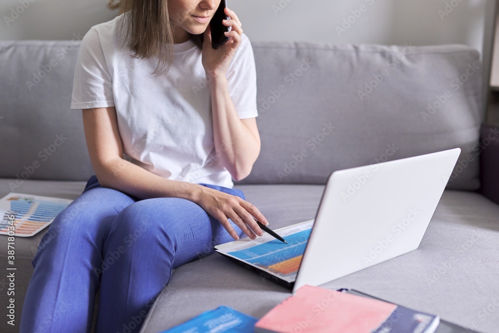 Young woman working remotely at home sitting on sofa with laptop Young woman working remotely at home sitting on sofa with laptop