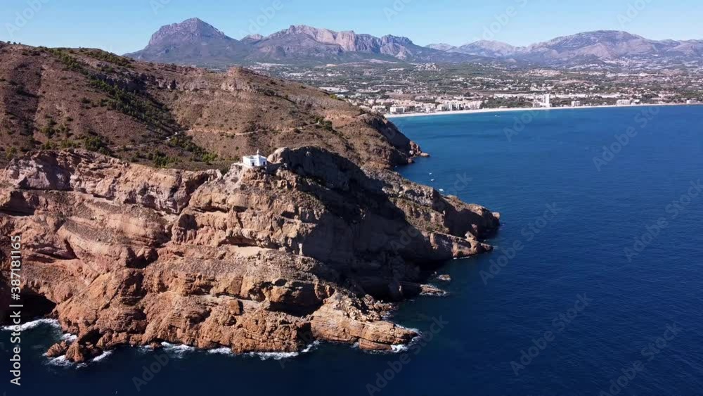 White lighthouse on the rocky shore. Aerial wide orbit shot. White lighthouse on the rocky shore. Aerial wide orbit shot.