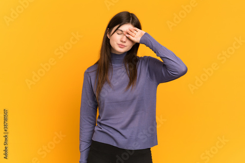 Young Ukrainian girl isolated on yellow background with tired and sick expression © luismolinero
