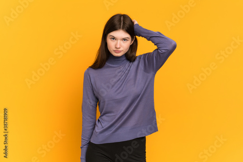 Young Ukrainian girl isolated on yellow background with an expression of frustration and not understanding © luismolinero