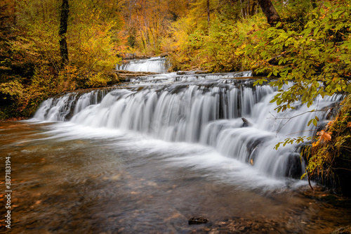 beautiful fall forest landscape with idyllic waterfall and pool