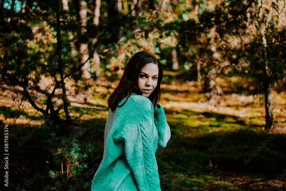 portrait of a girl with blue eyes in a turquoise sweater in the sunny forest portrait of a girl with blue eyes in a turquoise sweater in the sunny forest