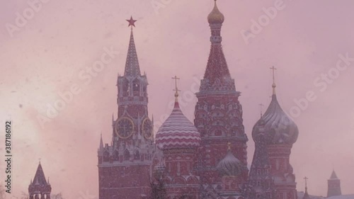Russian Winter. Russia, Moscow, Cathedral of the Intercession of Most Holy Theotokos on the Moat and view on Kremlin in a snowy winter evening at sunset. The Cathedral of Vasily the Blessed in heavy