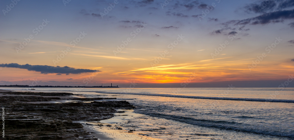 sunset on the Atlantic coast of France on the Ile de with the Baleines Lighthouse behind