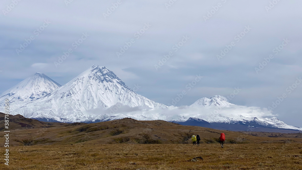 Three travelers are walking along the autumn tundra. Three travelers are walking along the autumn tundra.