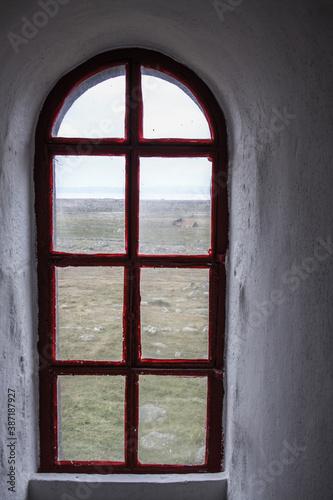 Rustic red wooden window in thick wall