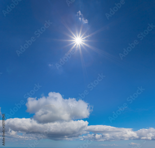 sparkle sun on a blue cloudy sky  natural sky background