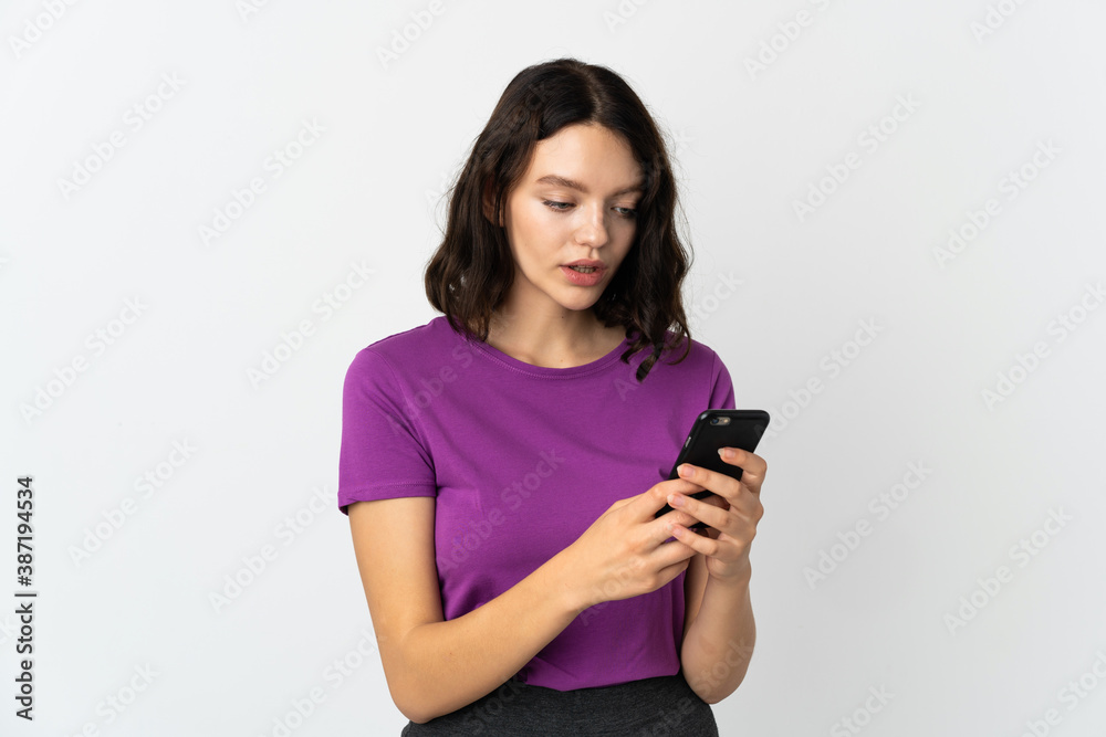 Teenager Ukrainian girl isolated on white background sending a message or email with the mobile Teenager Ukrainian girl isolated on white background sending a message or email with the mobile