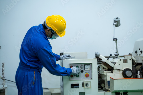 Industrial worker wearing protective mask to Protect Against Covid-19 working and checking production process at factory,Industrial concept,Coronavirus has turned into a global emergency.