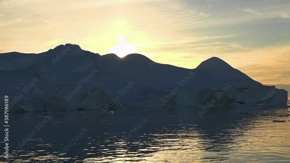 Greenland. Iceberg at sunset. Nature and landscapes of Greenland. Disko bay. Summer Midnight Sun and icebergs. Big blue ice in icefjord. Affected by climate change and global warming. Greenland. Iceberg at sunset. Nature and landscapes of Greenland. Disko bay. Summer Midnight Sun and icebergs. Big blue ice in icefjord. Affected by climate change and global warming.