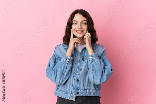 Teenager Ukrainian girl isolated on pink background smiling with a happy and pleasant expression