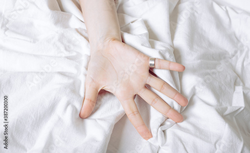Female hand on a white sheet. concept of passion, sex