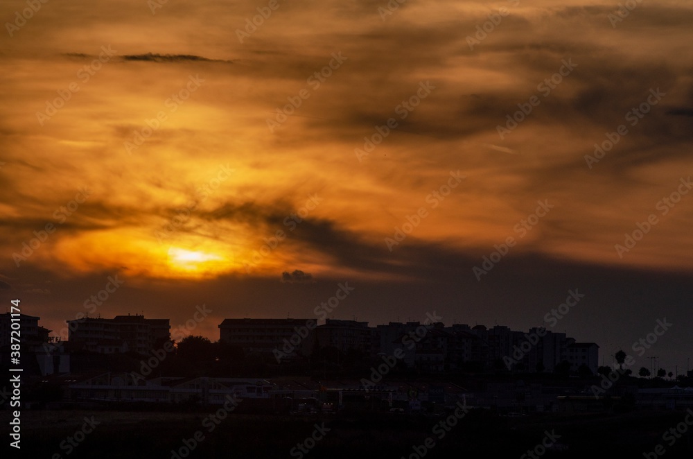 Urban panorama with sun at sunset