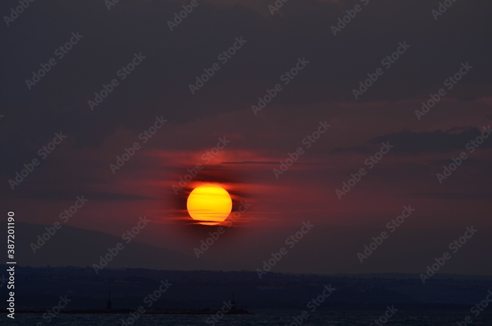 Beautiful seascape background with sun setting in the clouds Beautiful seascape background with sun setting in the clouds