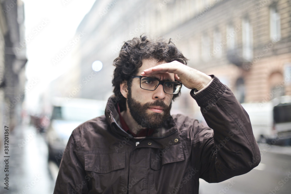 young man looks at the street looking for something
young man looks at the street looking for something