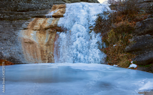 frozen waterfall on a mountain river  winter travel scene