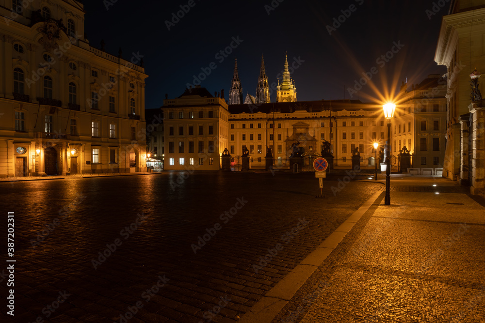  lit street light in a city street at night. glowing lamp at night in the old town of prague in the czech republic 
and in the background the view of the city of Prague at night and the 
