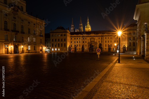  lit street light in a city street at night. glowing lamp at night in the old town of prague in the czech republic and in the background the view of the city of Prague at night and the 