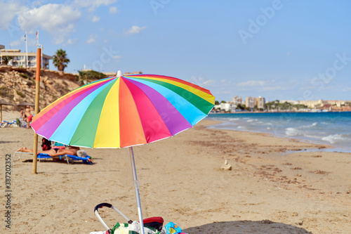 Multi colored parasol on the beach of Mil Palmeras, Spain