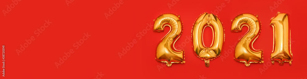 Foil Golden Christmas 2021 balloons in form of numbers isolated on red background. Happy New Year 2021. Flat lay, top view. Banner. Copy space for text Foil Golden Christmas 2021 balloons in form of numbers isolated on red background. Happy New Year 2021. Flat lay, top view. Banner. Copy space for text
