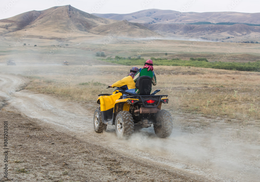 ATVs with people riding over rough terrain ATVs with people riding over rough terrain