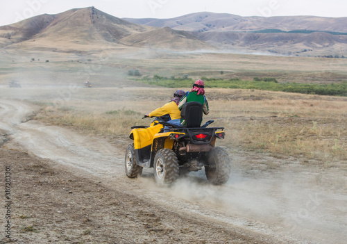 ATVs with people riding over rough terrain