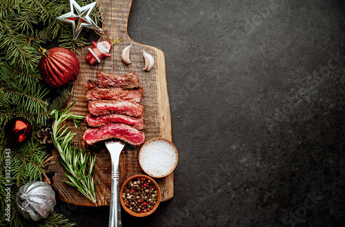 Fototapeta Different degrees of roasting of steak on a meat fork for Christmas on a backgro
