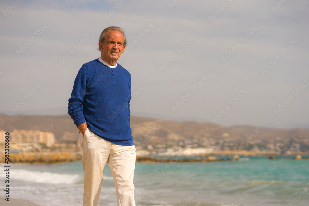Senior pensioner walking relaxed on the beach - retired old man on his 70s looking at the sea thoughtful and contemplative in health concept Senior pensioner walking relaxed on the beach - retired old man on his 70s looking at the sea thoughtful and contemplative in health concept