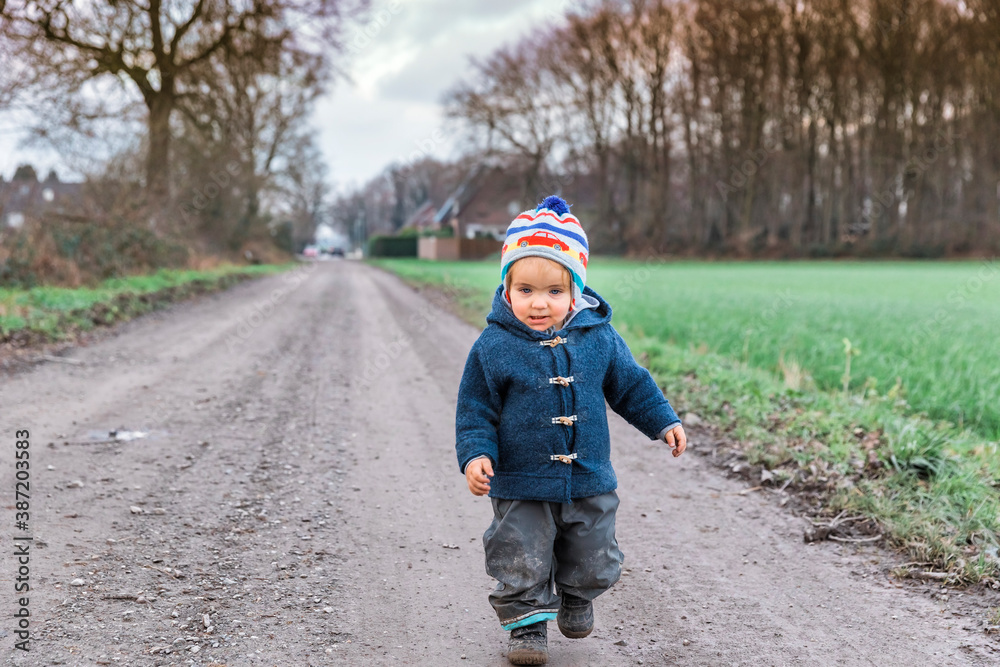 Fototapeta premium Happy toddler running on footpath