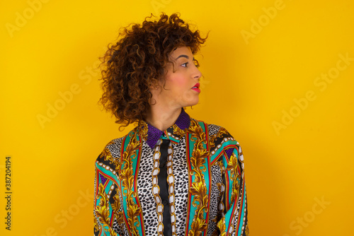 Profile of serious woman isolated over grey studio wall with healthy pure skin has contemplative expression ready to have outdoor walk © Jihan