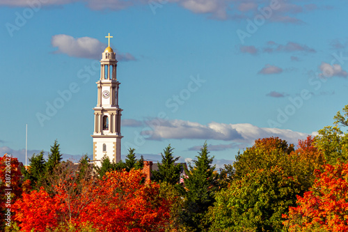 A scenic view of Frederick on a sunny afternoon in fall. The tallest building in city (bell tower of St. John the Evangelist Catholic Church) towers above trees in autumn colors. photo