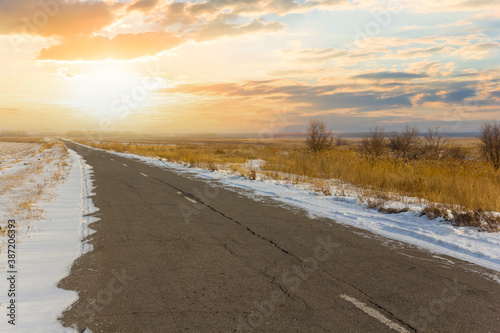 Foto asphalt road among a snowbound prairie at the sunset