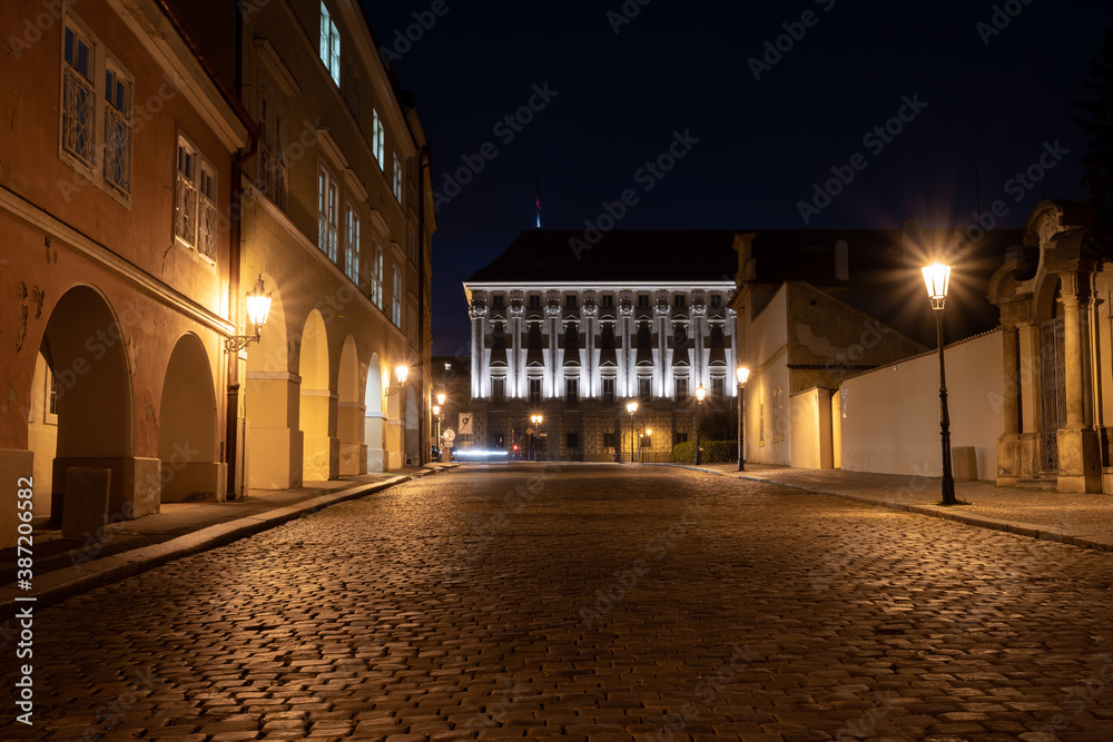 Fototapeta premium street light in a city street at night and in the background is an old monastery from the 12th