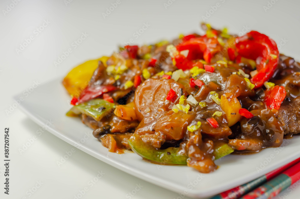 Cooked marinated beef slices with a savory black beef sauce, peppers and onions