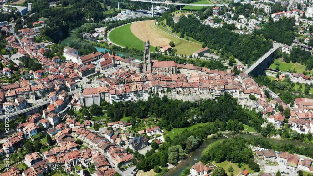 Aerial view of Fribourg town and its cathedral, Saint-Nicolas, Switzerland. Vue aérienne de la vieille ville de Fribourg filmée en drone, Suisse 4k.