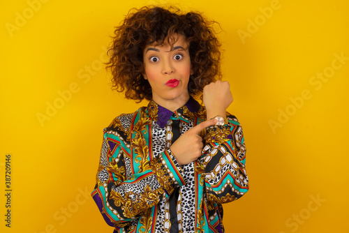 Beautiful young Caucasian woman over isolated background In hurry pointing to watch time, impatience, upset and angry for deadline delay