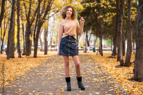 Portrait of a young beautiful girl in beige sweater and black skirt