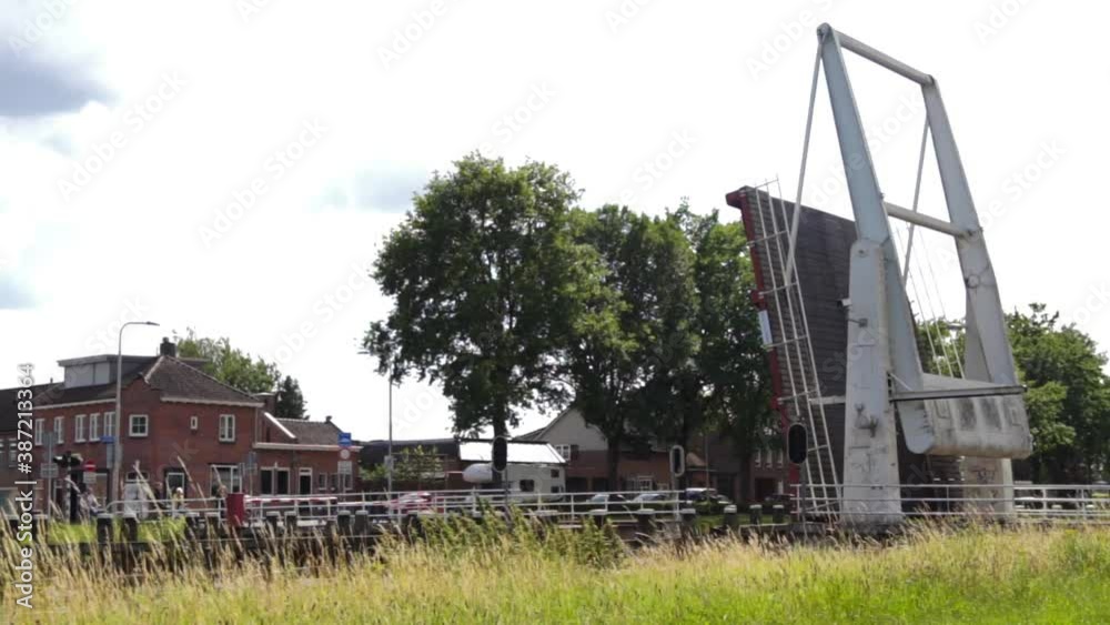 Dutch bridge opening on the canal to let the boat pass in the middle of town. Water architecture from Netherlands. Dutch bridge opening on the canal to let the boat pass in the middle of town. Water architecture from Netherlands.