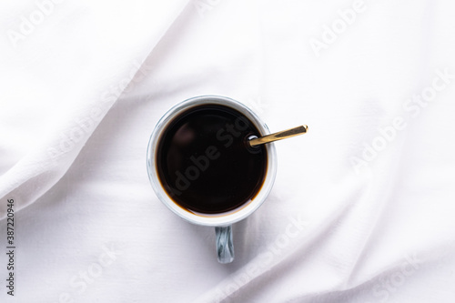 Photography a cup of morning coffee on a snow-white sheet