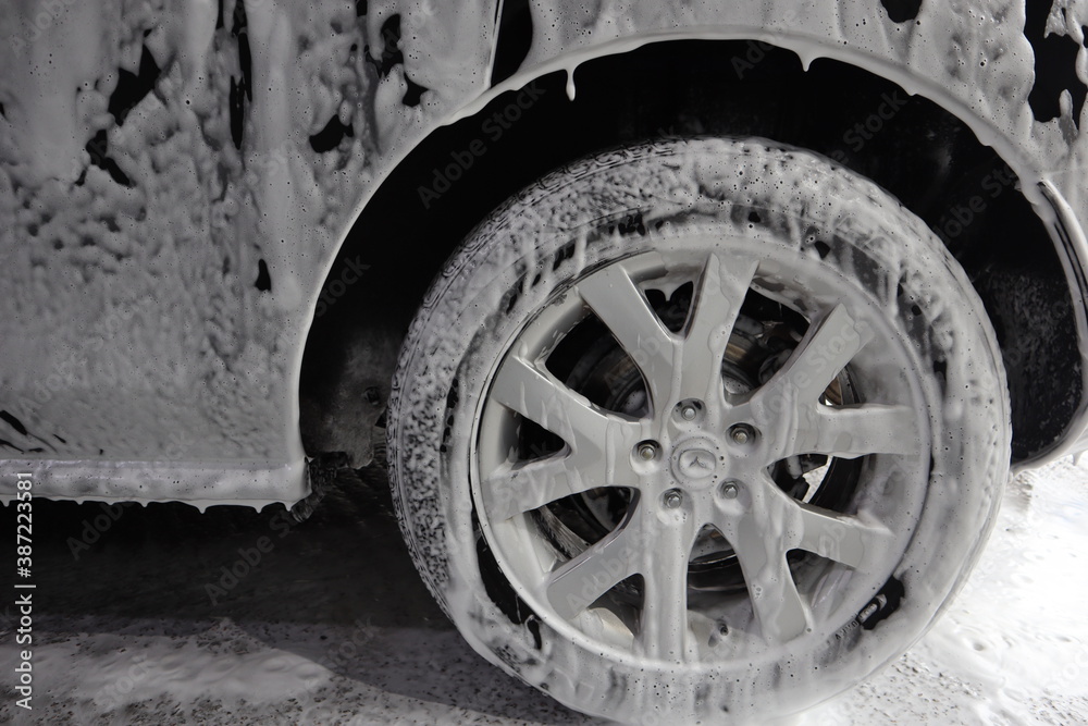 car wheel is covered with soapy foam