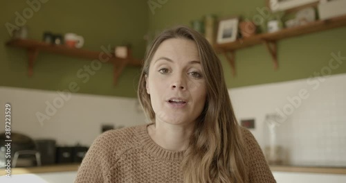 Female on video call with colleagues looking at camera, working from home during covid pandemic lockdown photo