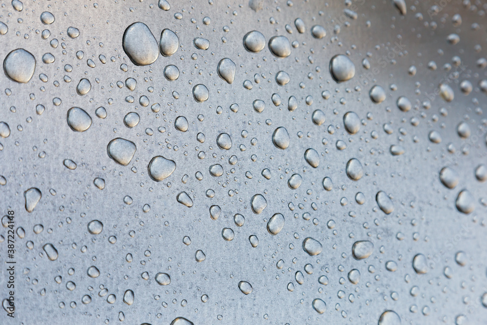 Water drops on a metal surface, background, shallow depth of field.