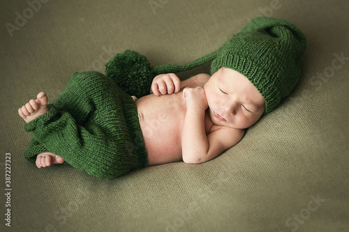 sleeping newborn baby boy in green cap