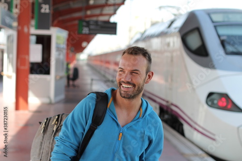 Blonde man smiling in train station 